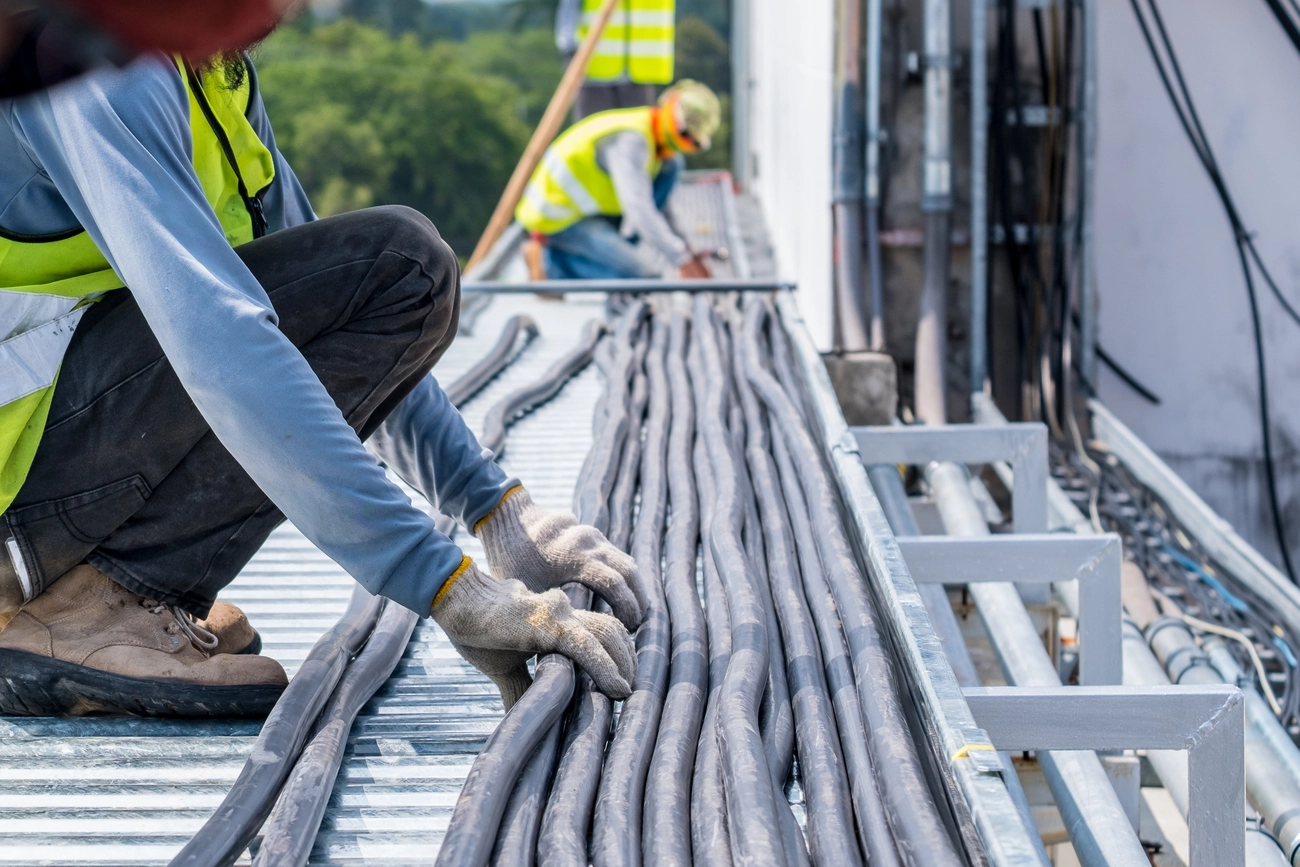 M-J tief.und Rohrleitungsbau GmbH - M-J tief.und Rohrleitungsbau GmbH - Arbeiter bewegen Kabel auf Baustellen.